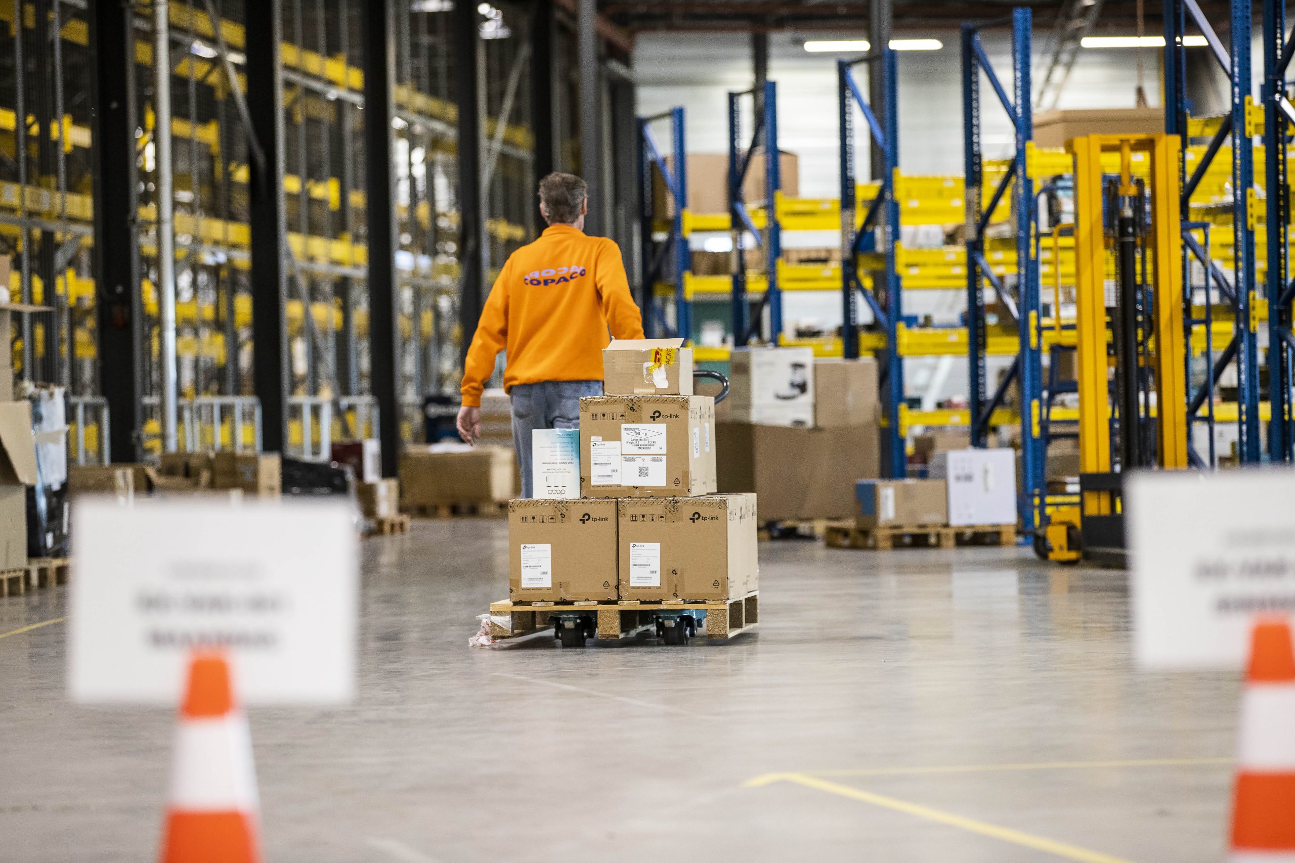 Een medewerker van retourlogistiek brengt een retourzending rond in het magazijn van Yours