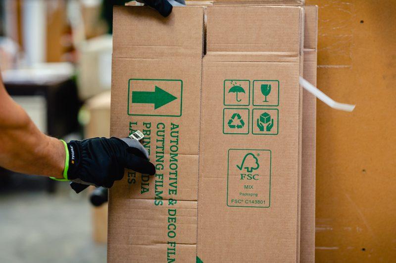 FSC-gecertificeerd karton wordt vasteghouden. Hierop staan verschillende keurmerken