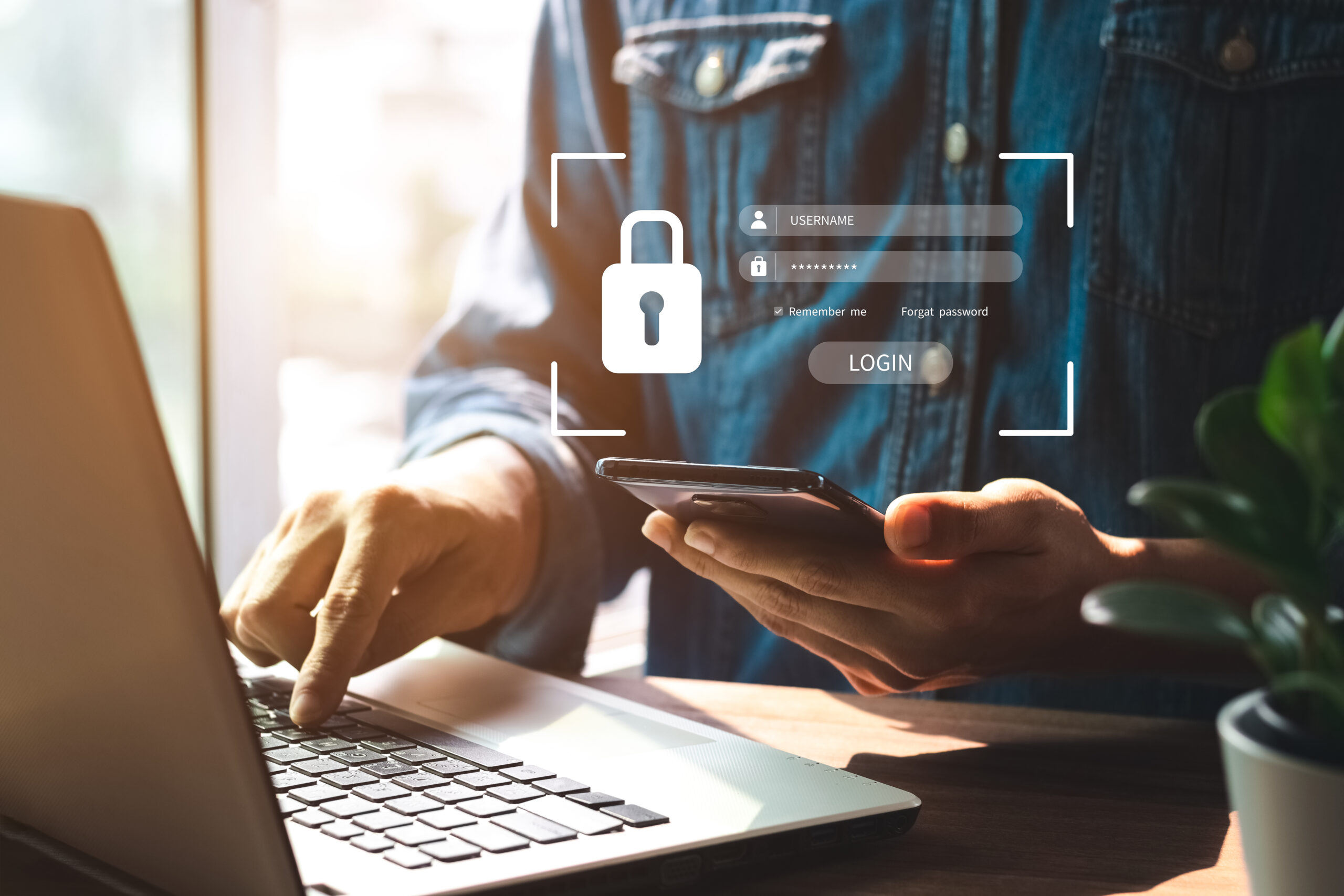 Persoon die met zijn telefoon inlogt op zijn computer door middel van een Multifactorauthenticatie